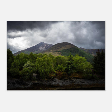 Glencoe and Glen Etive wall art showing bright green trees in front of rocky Highland mountains under dark storm clouds in the Scottish glen