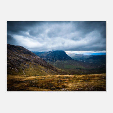 Buachaille Etive Mòr Glencoe wall art showing the dark pyramid-shaped mountain in the centre of a rocky Highland glen under heavy clouds and cool blue light