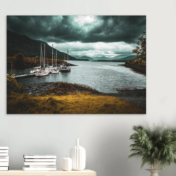 Ballachulish dockyard wall art showing yachts moored at a small dock with dark hills, teal water and heavy storm clouds on the Scottish west coast
