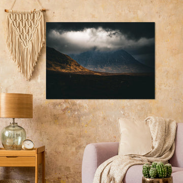 Glencoe sunrise wall art showing Buachaille Etive Mòr under dark storm clouds with a strip of warm light across the foreground moorland