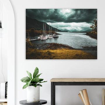 Ballachulish dockyard wall art showing yachts moored at a small dock with dark hills, teal water and heavy storm clouds on the Scottish west coast