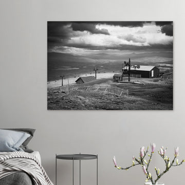 Glencoe Mountain View wall art showing a black and white panorama from Glencoe Mountain with ski lifts, small huts and a wide Highland landscape under dramatic clouds