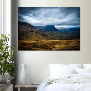 Buachaille Etive Mòr Glencoe wall art showing the dark pyramid-shaped mountain in the centre of a rocky Highland glen under heavy clouds and cool blue light