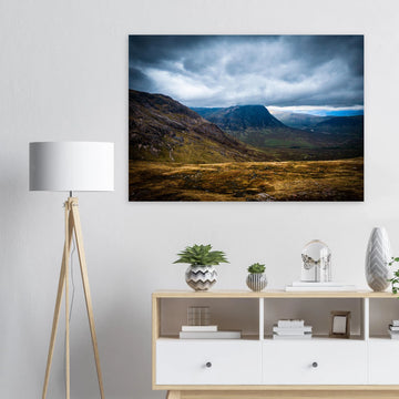 Buachaille Etive Mòr Glencoe wall art showing the dark pyramid-shaped mountain in the centre of a rocky Highland glen under heavy clouds and cool blue light