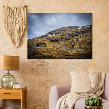 Glencoe Mountain Ski Lift Top wall art showing a wooden hut and fences on a rocky hillside with ski lift towers, snow patches and grey clouds at Glencoe Mountain Resort