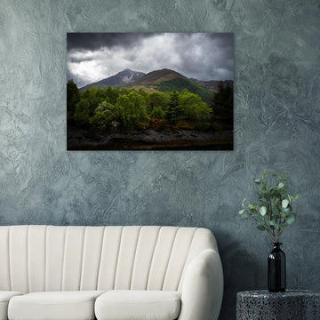 Glencoe and Glen Etive wall art showing bright green trees in front of rocky Highland mountains under dark storm clouds in the Scottish glen