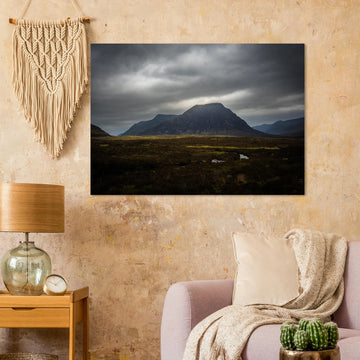 Buachaille Etive Mòr stormy sunrise wall art showing the dark Glencoe mountain under heavy clouds with a strip of light over the foreground moorland