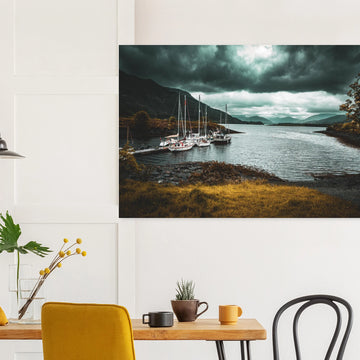 Ballachulish dockyard wall art showing yachts moored at a small dock with dark hills, teal water and heavy storm clouds on the Scottish west coast