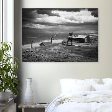 Glencoe Mountain View wall art showing a black and white panorama from Glencoe Mountain with ski lifts, small huts and a wide Highland landscape under dramatic clouds