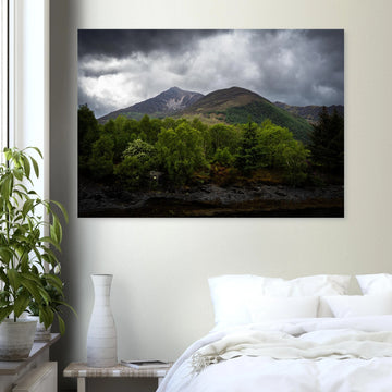 Glencoe and Glen Etive wall art showing bright green trees in front of rocky Highland mountains under dark storm clouds in the Scottish glen