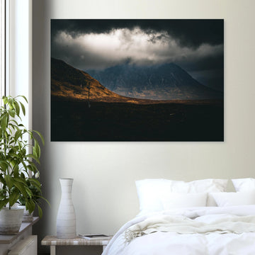 Glencoe sunrise wall art showing Buachaille Etive Mòr under dark storm clouds with a strip of warm light across the foreground moorland