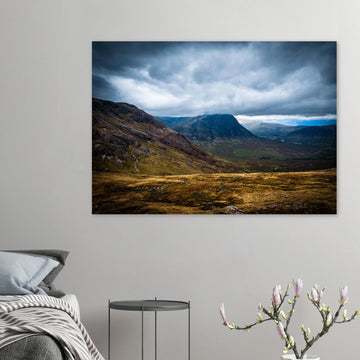 Buachaille Etive Mòr Glencoe wall art showing the dark pyramid-shaped mountain in the centre of a rocky Highland glen under heavy clouds and cool blue light