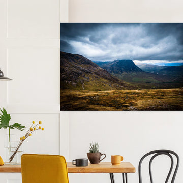 Buachaille Etive Mòr Glencoe wall art showing the dark pyramid-shaped mountain in the centre of a rocky Highland glen under heavy clouds and cool blue light