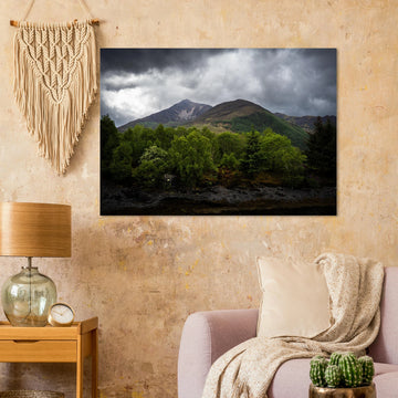 Glencoe and Glen Etive wall art showing bright green trees in front of rocky Highland mountains under dark storm clouds in the Scottish glen