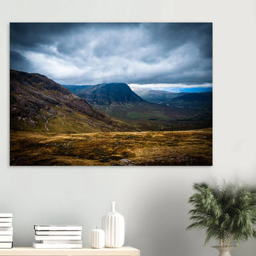 Buachaille Etive Mòr Glencoe wall art showing the dark pyramid-shaped mountain in the centre of a rocky Highland glen under heavy clouds and cool blue light