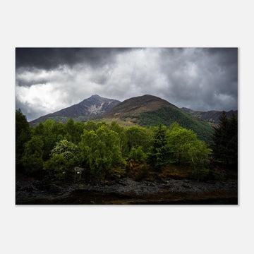 Glencoe and Glen Etive wall art showing bright green trees in front of rocky Highland mountains under dark storm clouds in the Scottish glen