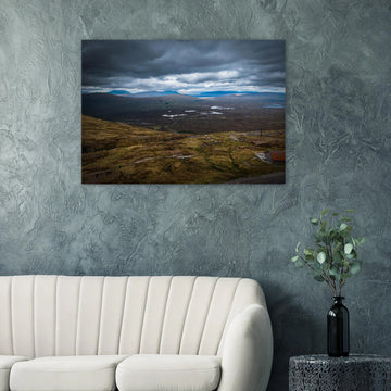 Glencoe Valley From Above wall art showing a wide Highland moor with distant blue hills, scattered lochans and heavy clouds over the Glencoe landscape