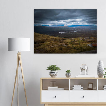 Glencoe Valley From Above wall art showing a wide Highland moor with distant blue hills, scattered lochans and heavy clouds over the Glencoe landscape