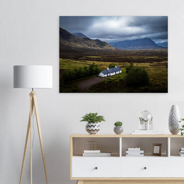 Blackrock Cottage Buachaille Etive Mòr wall art showing the white cottage in front of a dramatic Scottish Highlands mountain under dark storm clouds and moody light