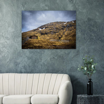 Glencoe Mountain Ski Lift Top wall art showing a wooden hut and fences on a rocky hillside with ski lift towers, snow patches and grey clouds at Glencoe Mountain Resort