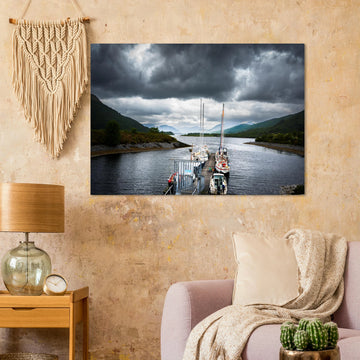 Ballachulish Harbour wall art showing yachts lined up along a narrow pier between green hills with dark storm clouds over the Scottish waterway