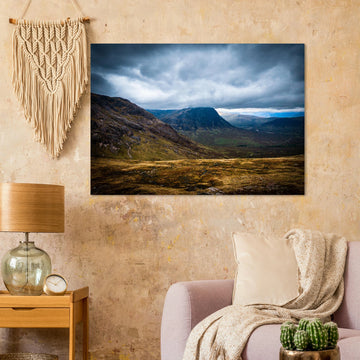 Buachaille Etive Mòr Glencoe wall art showing the dark pyramid-shaped mountain in the centre of a rocky Highland glen under heavy clouds and cool blue light