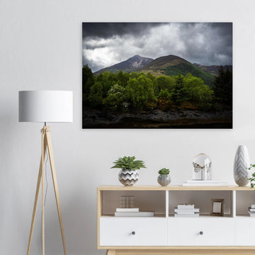 Glencoe and Glen Etive wall art showing bright green trees in front of rocky Highland mountains under dark storm clouds in the Scottish glen