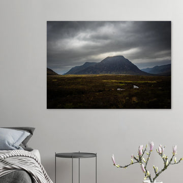 Buachaille Etive Mòr stormy sunrise wall art showing the dark Glencoe mountain under heavy clouds with a strip of light over the foreground moorland