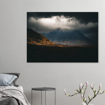 Glencoe sunrise wall art showing Buachaille Etive Mòr under dark storm clouds with a strip of warm light across the foreground moorland